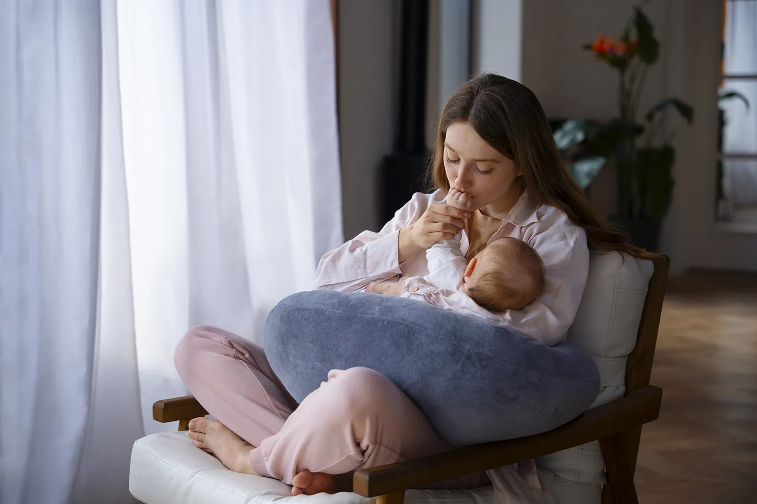 Mãe em poltrona amamentando filhos - cuidados com a alimentação no calor