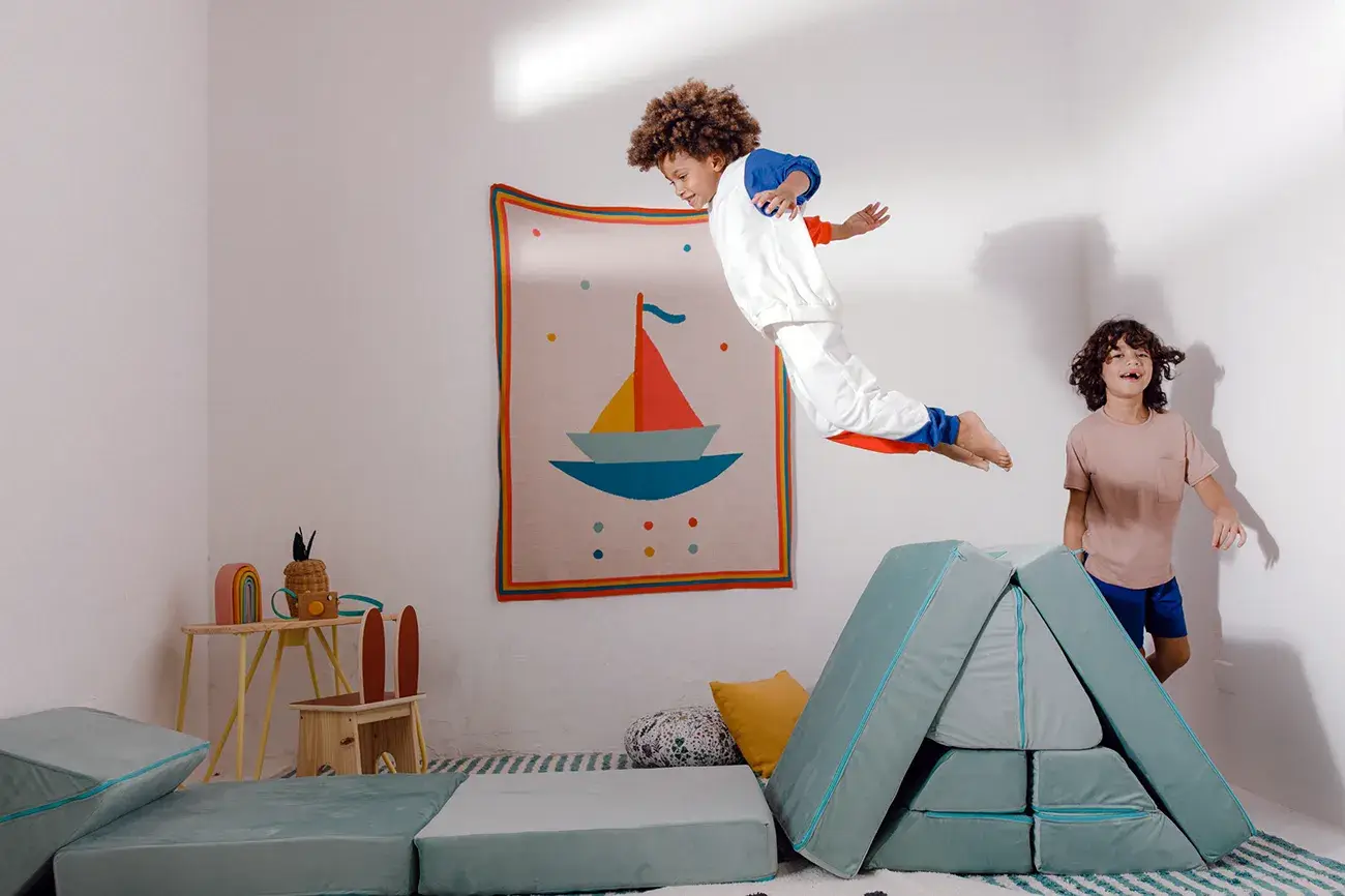 Menino pequeno pulando no sofá de brincar da Five Little Monkeys