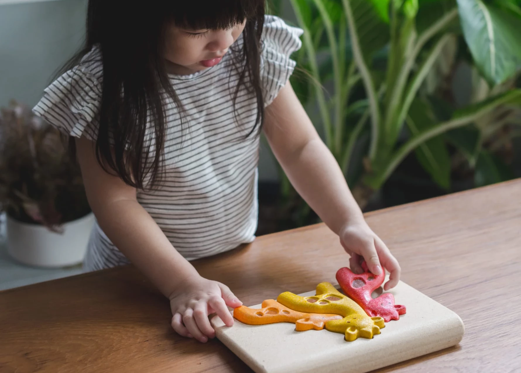 Menina brincando com brinquedo Plan Toys® - Just Real Moms