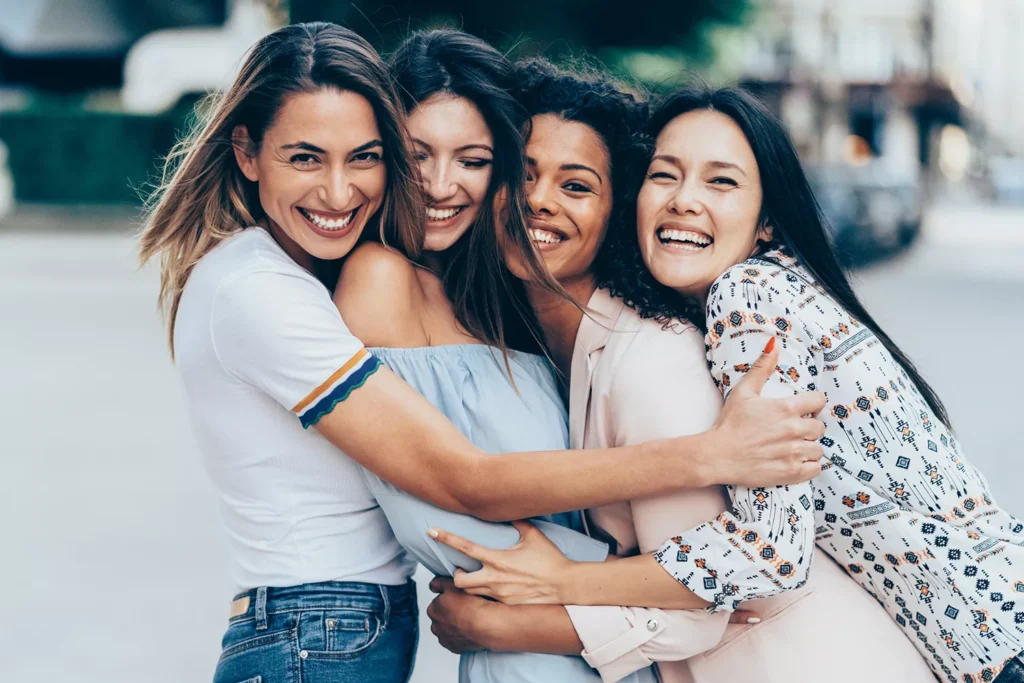 4 mulheres amigas abraçadas sorrindo