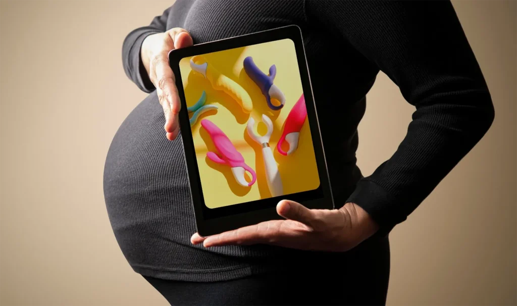 Zoom em barriga de mulher grávida, segurando um ipad com imagens de vibradores no post sobre sexo na gravidez