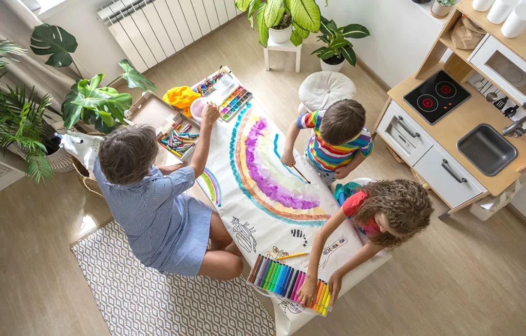 Crianças com mãe brincando de pintura para o Dia das Crianças 2024