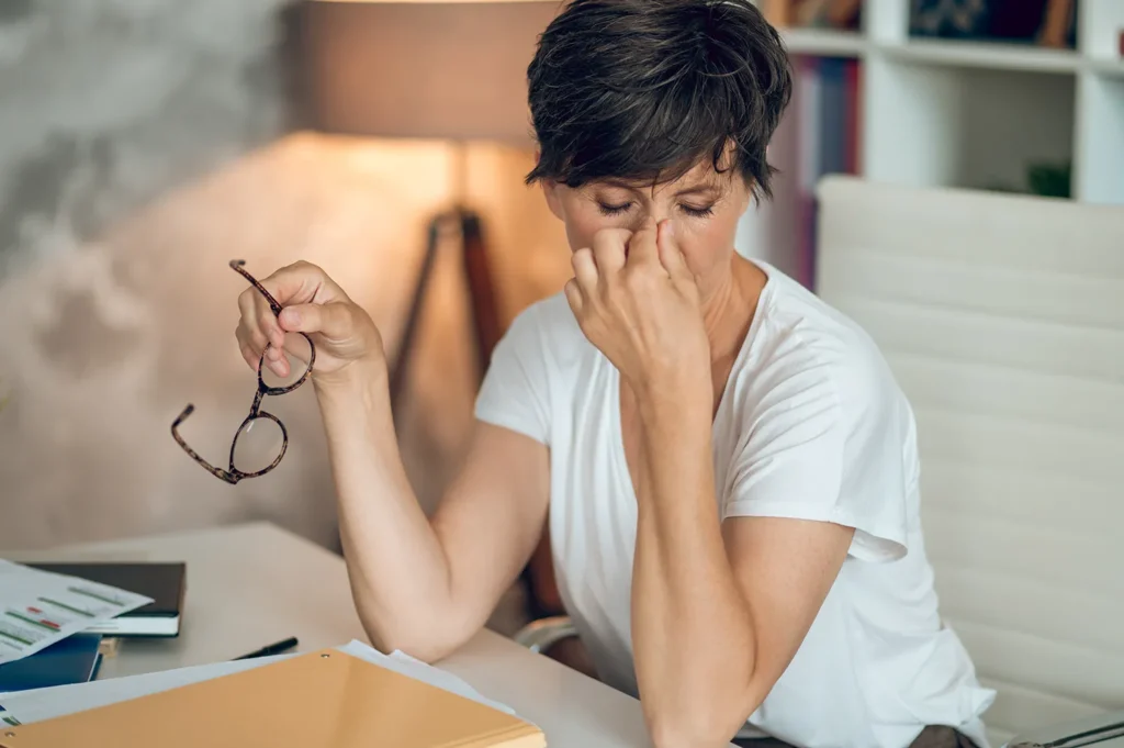 Mulher com olhos secos e irritados, por causa da menopausa