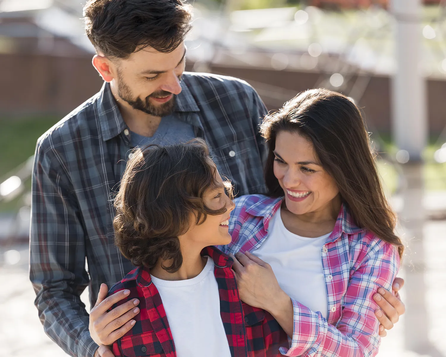 Mãe e pai com filho adolescente conversando felizes