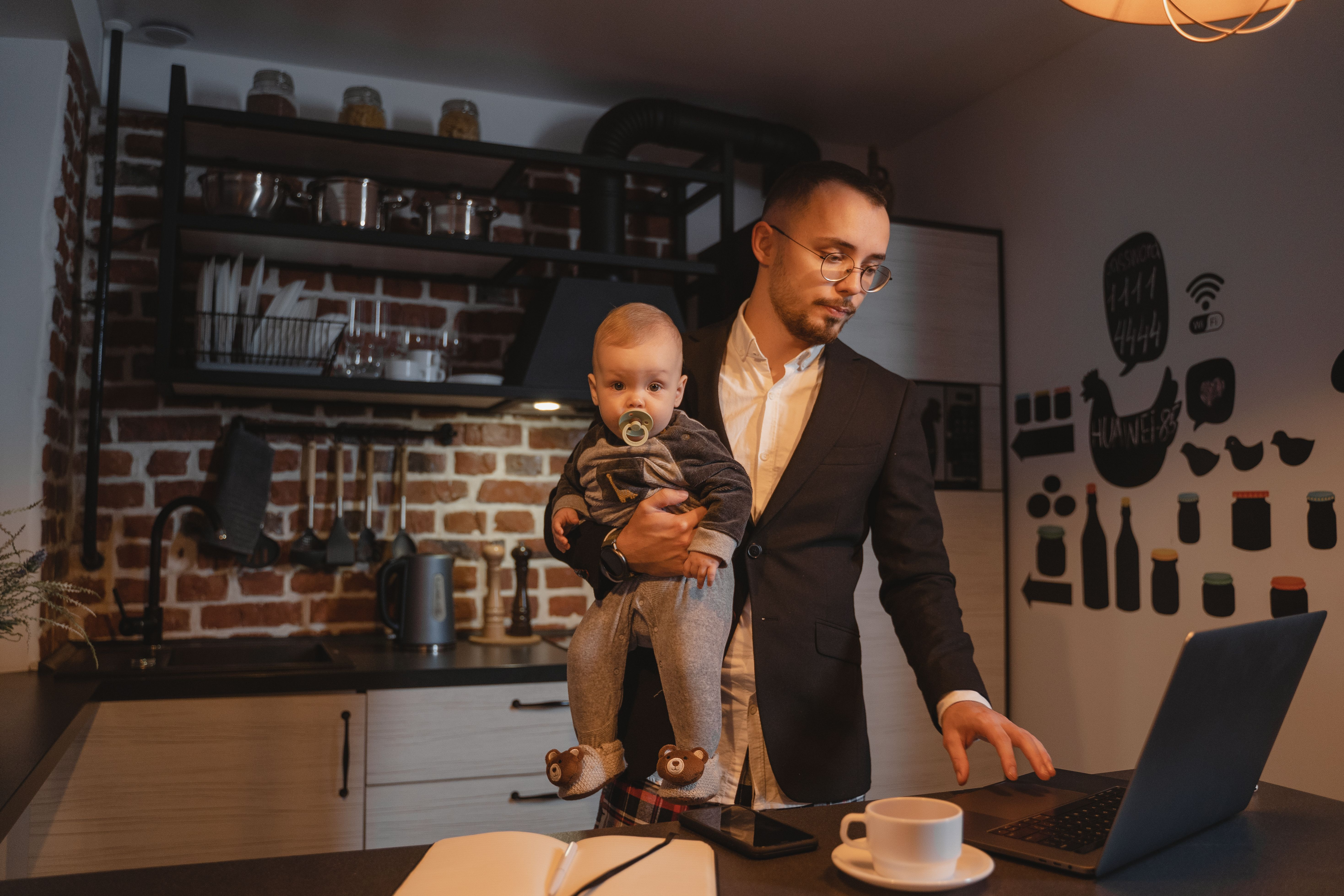 Pai empreendedor segurando seu filho no colo enquanto trabalha