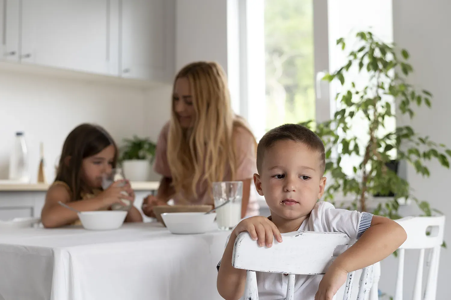 Menino sentado à mesa com seletividade alimentar infantil