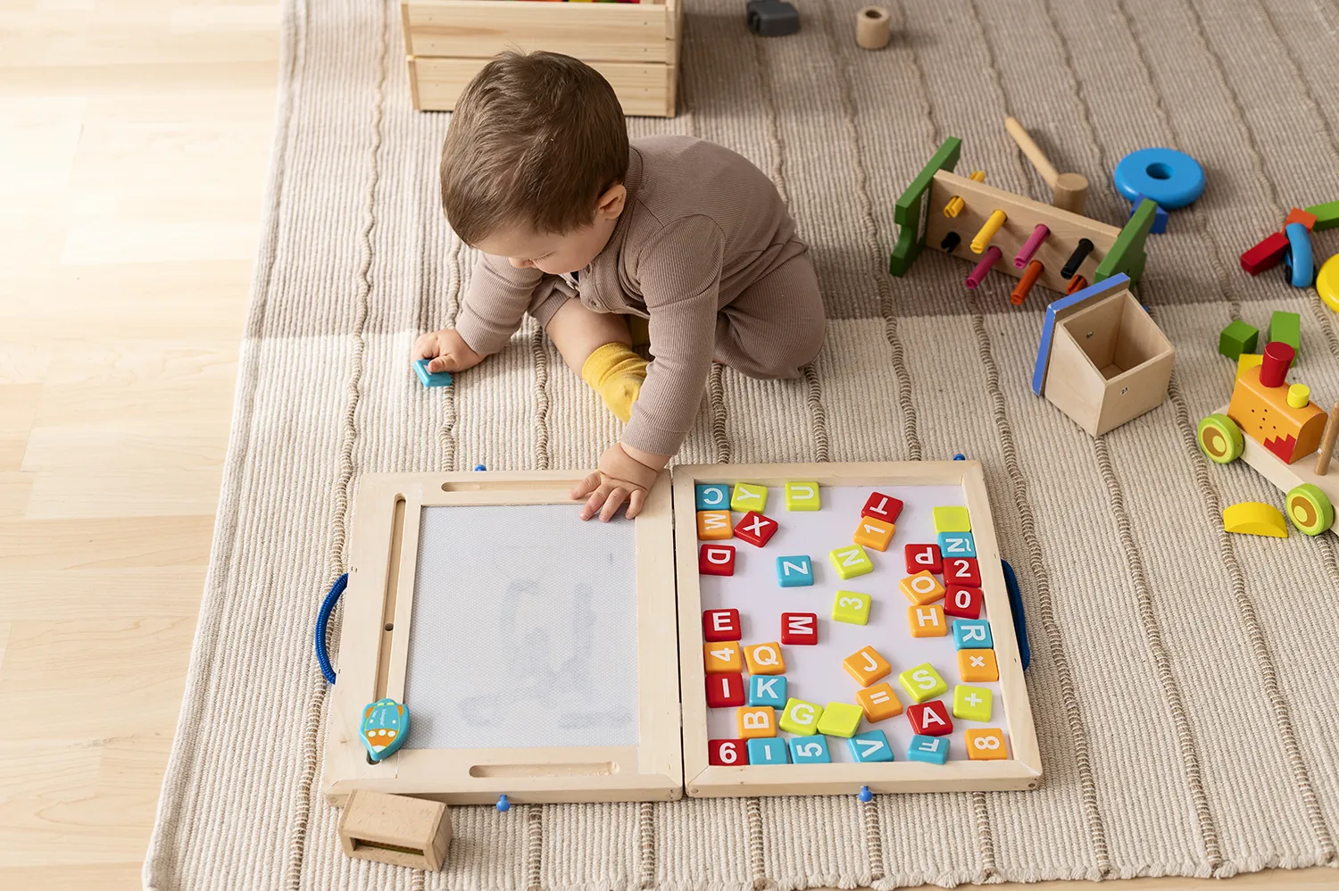 Bebê com Brinquedos educativos no chão brincando