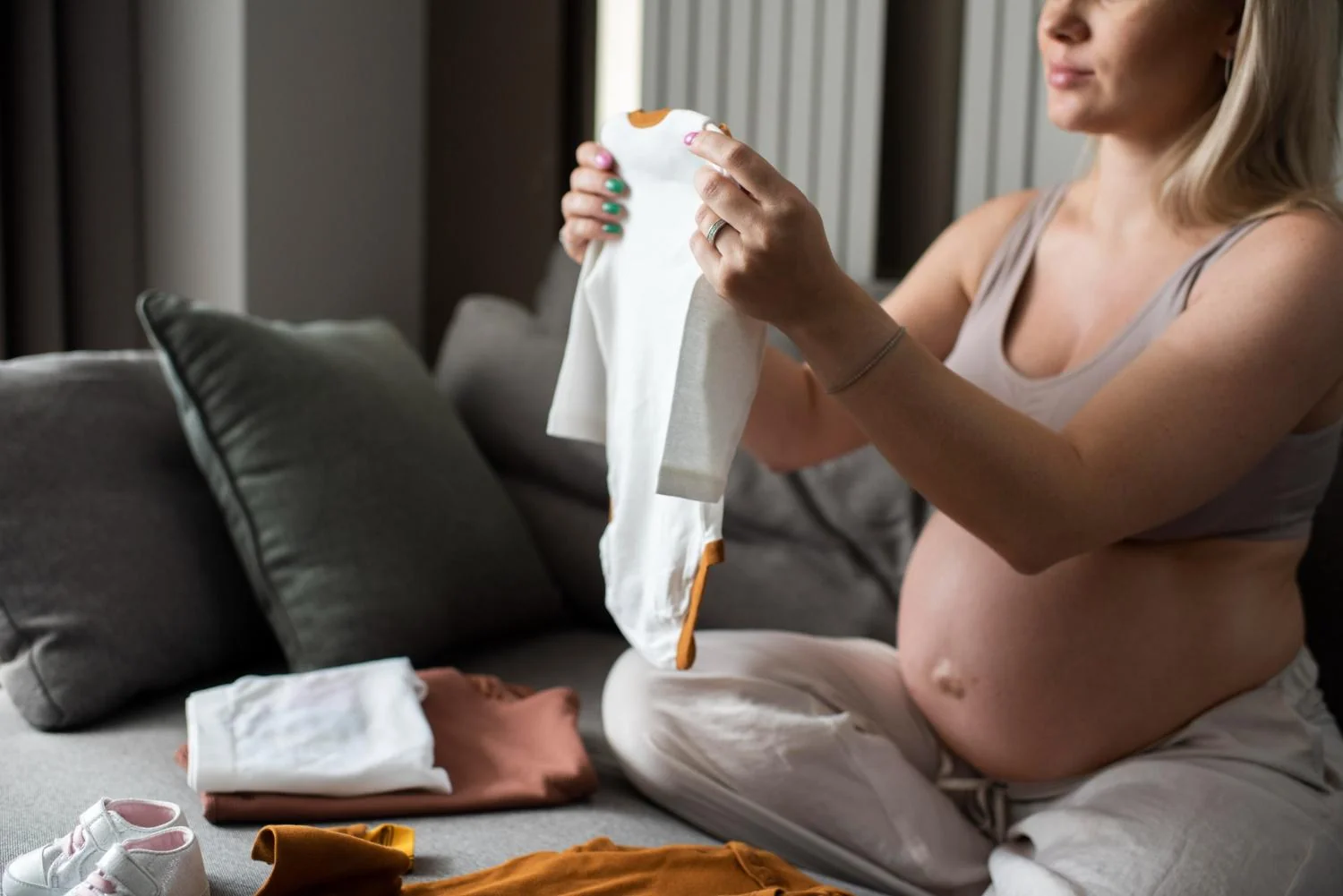Mulher grávida organizando bolsa de maternidade.