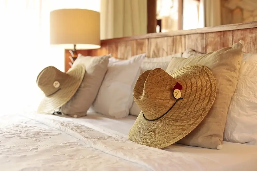 Close de cama de casal no quarto da Pousada Anttunina em Alagoas - para as férias de julho