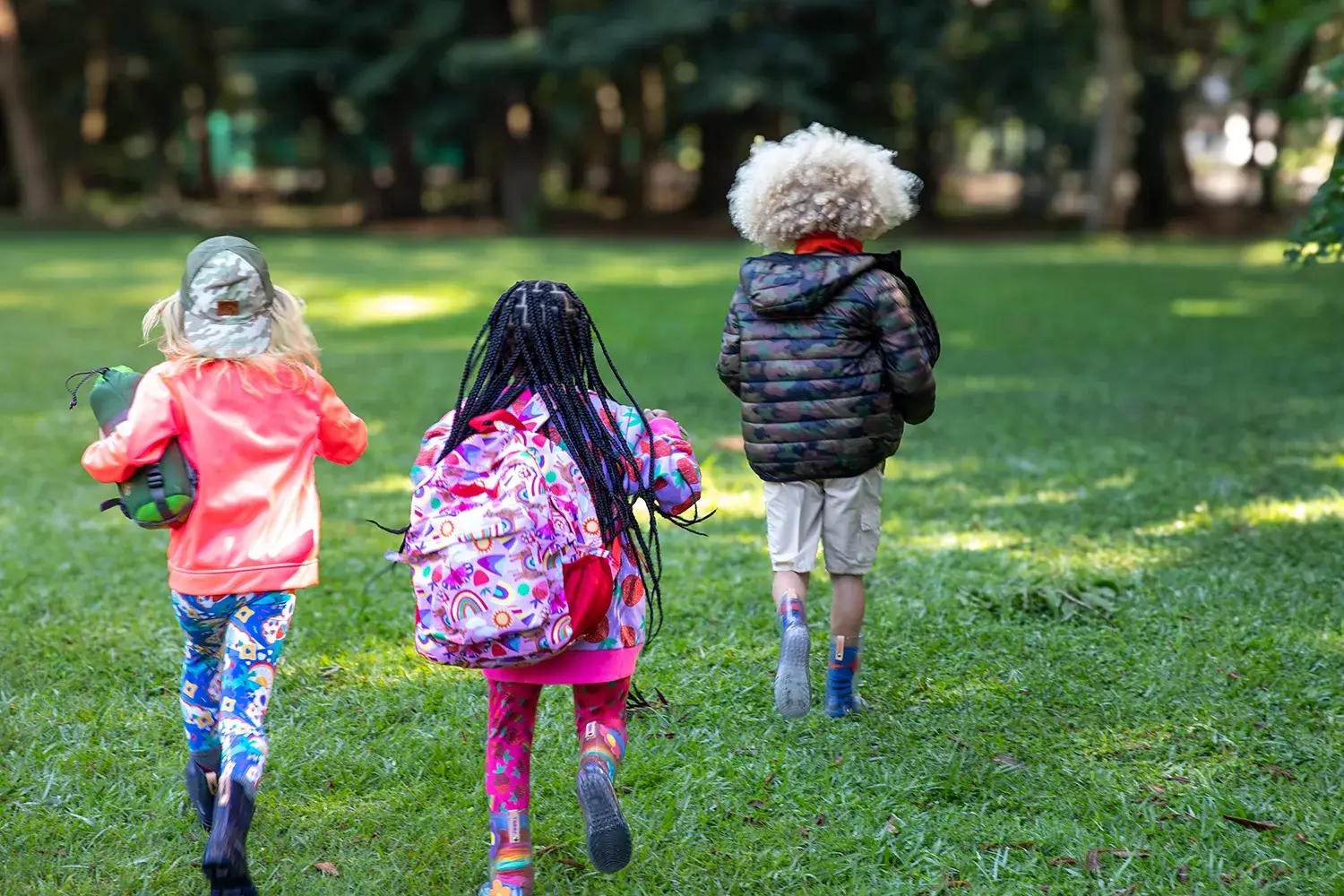 Crianças correndo em campo verde em campanha da marca infantil Jooba
