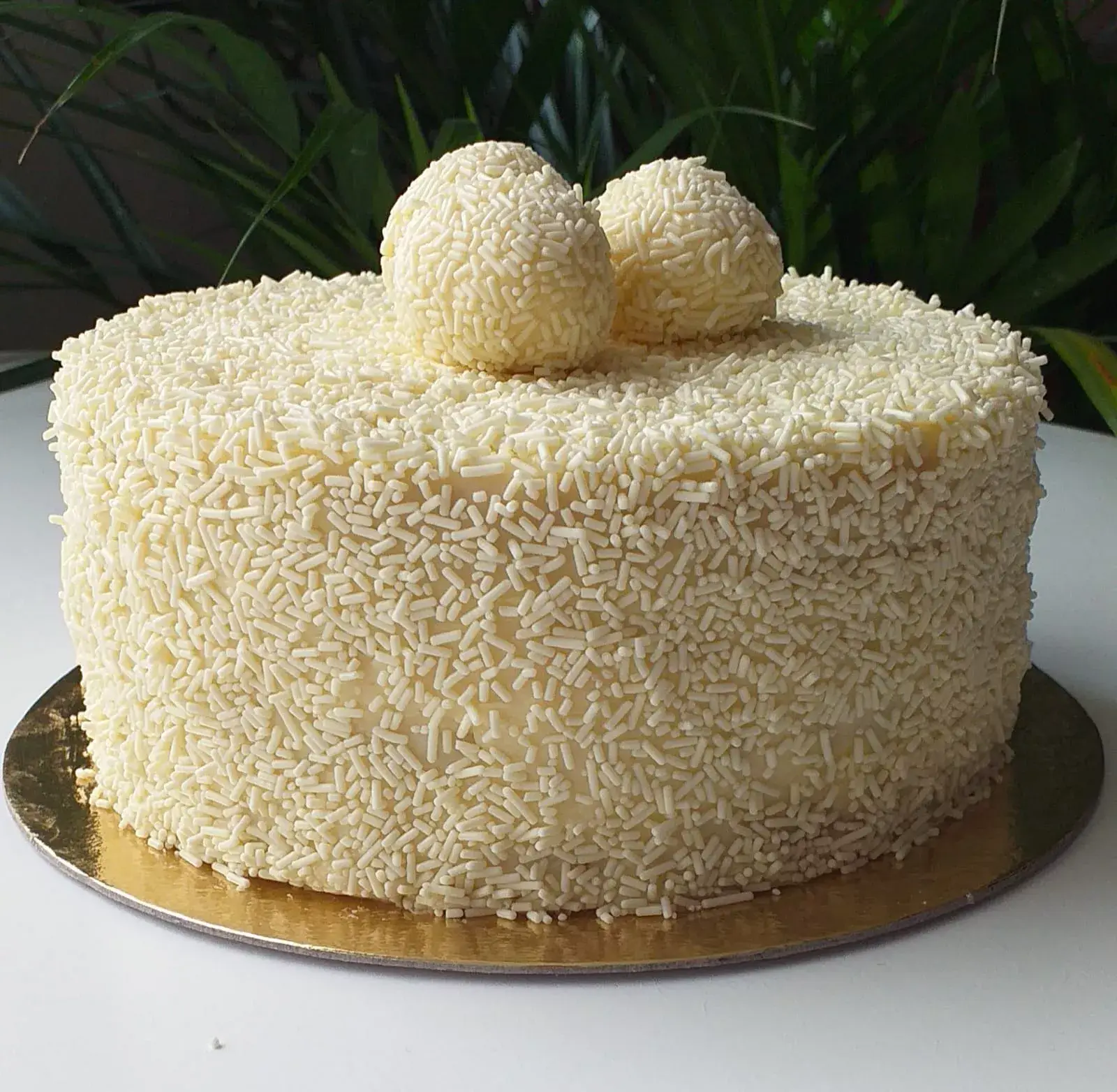 Bolo de brigadeiro branco da LeTapia aberto no meio com cheio - Just Real moms