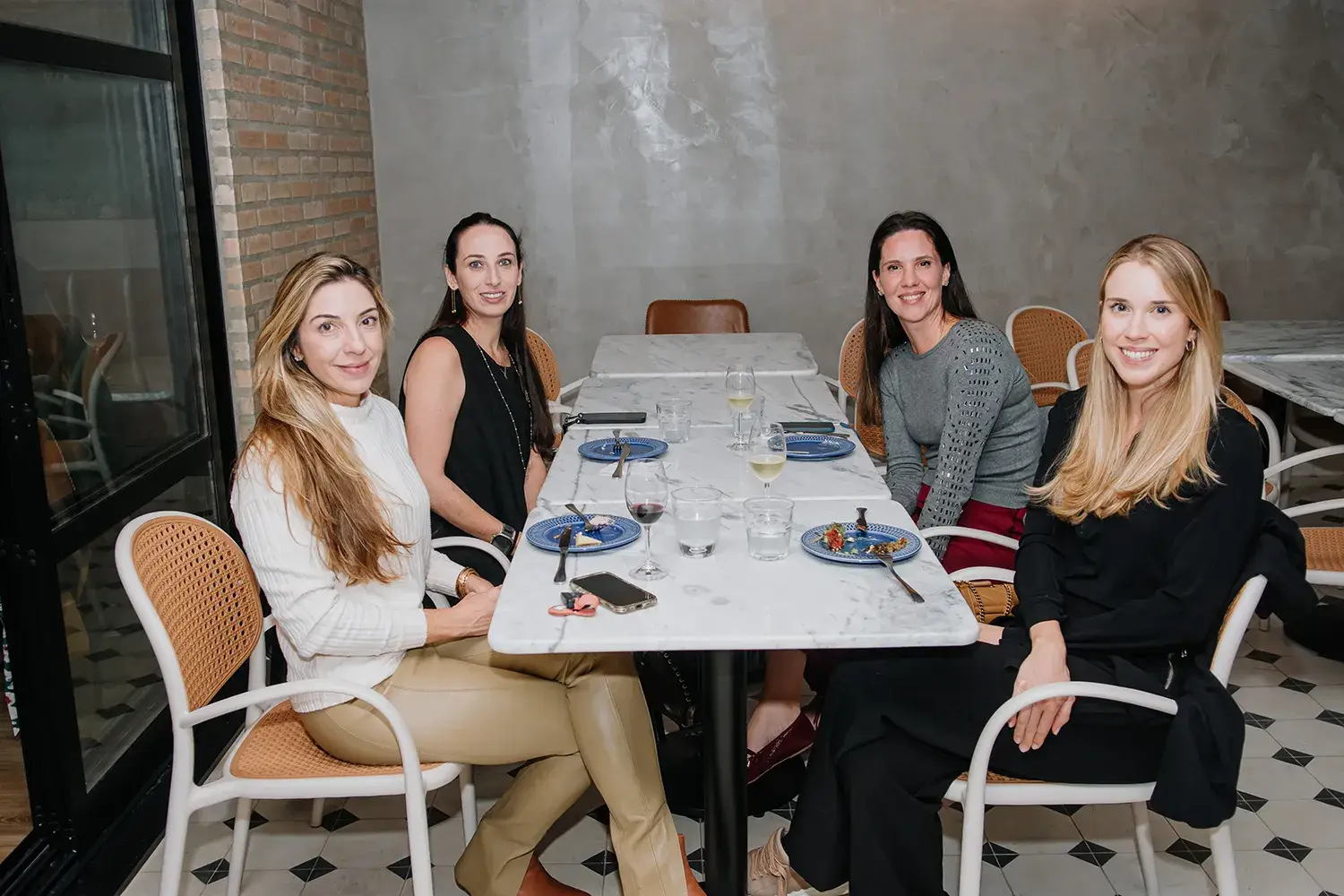 Convidadas sentadas na área externa da Fatto Delicatessen na experiência sensorial das Mães da Pracinha da Vila Nova Conceição e Just Real Moms