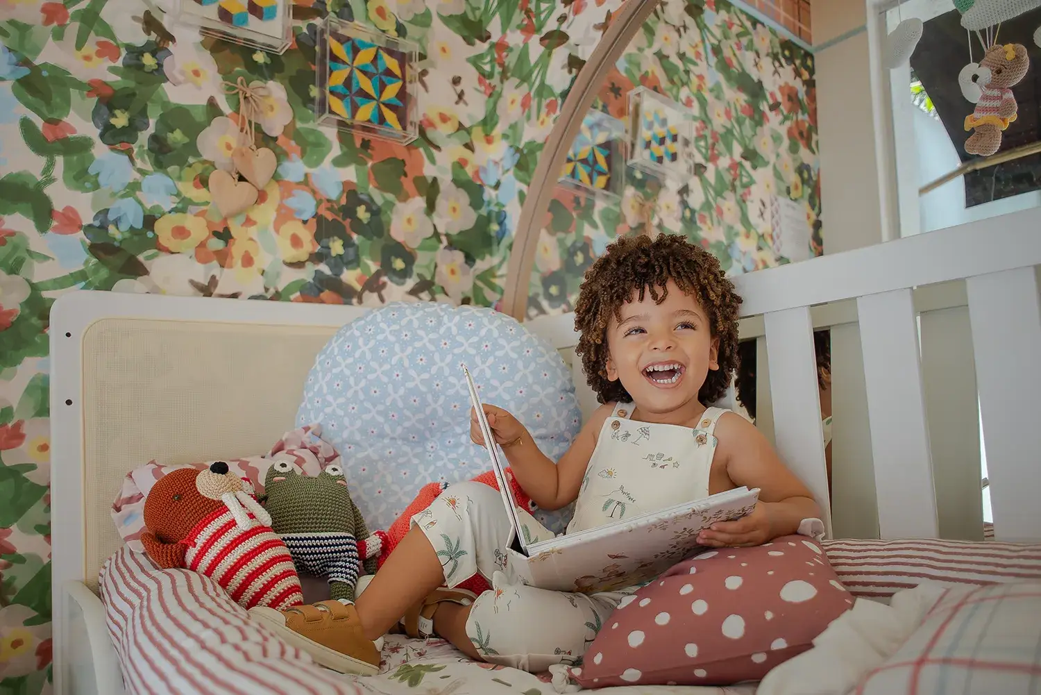 Menina de macacão infantil da Bambini Per Bambini lendo livro