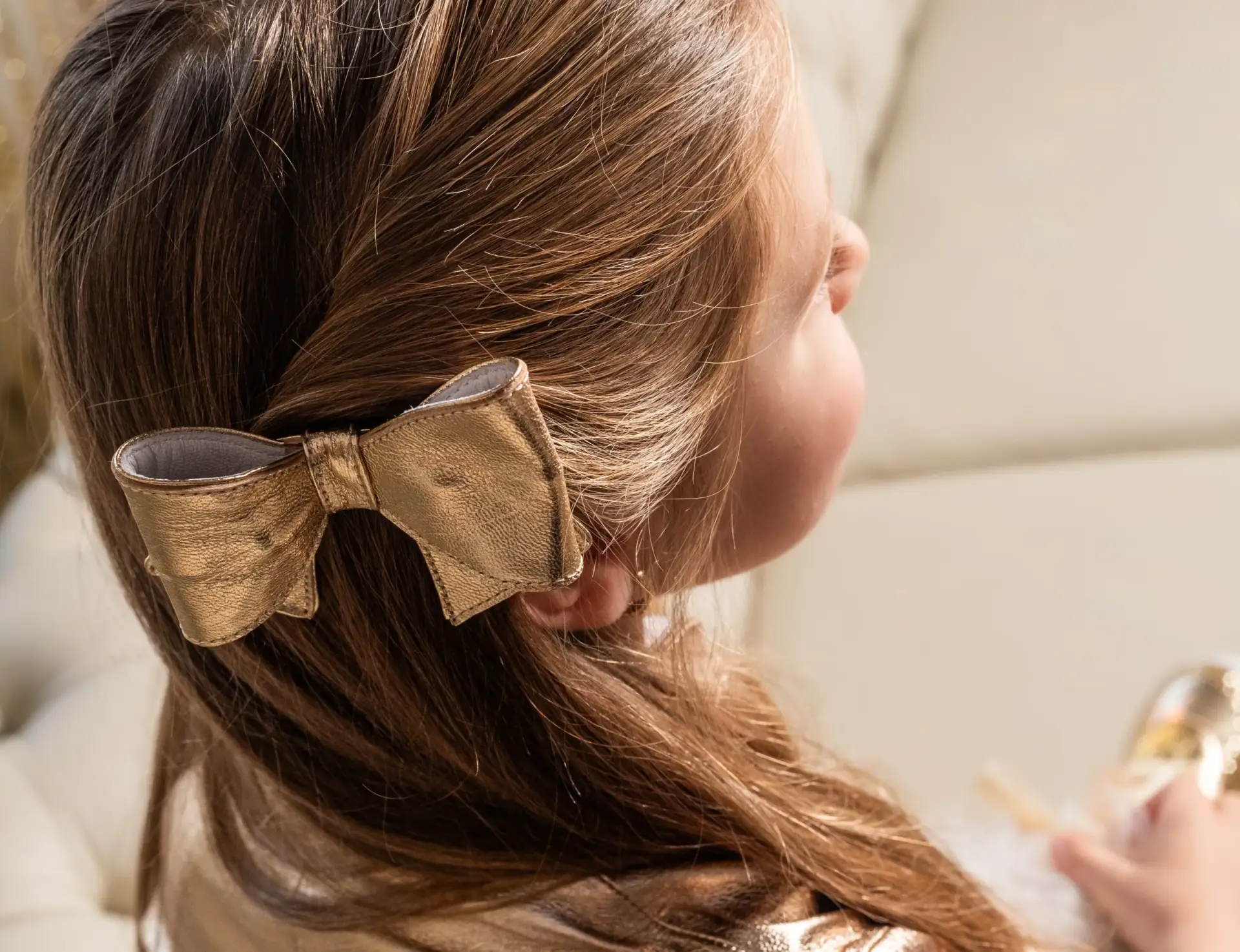 Laço dourado de festa infantil da Amoreco Calçados